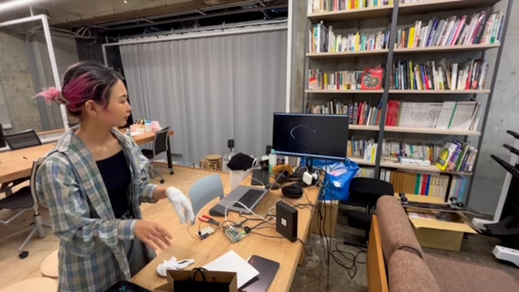 後輩と一緒に手話の軌跡をリアルタイムで表示させる<br />デバイスを開発している様子